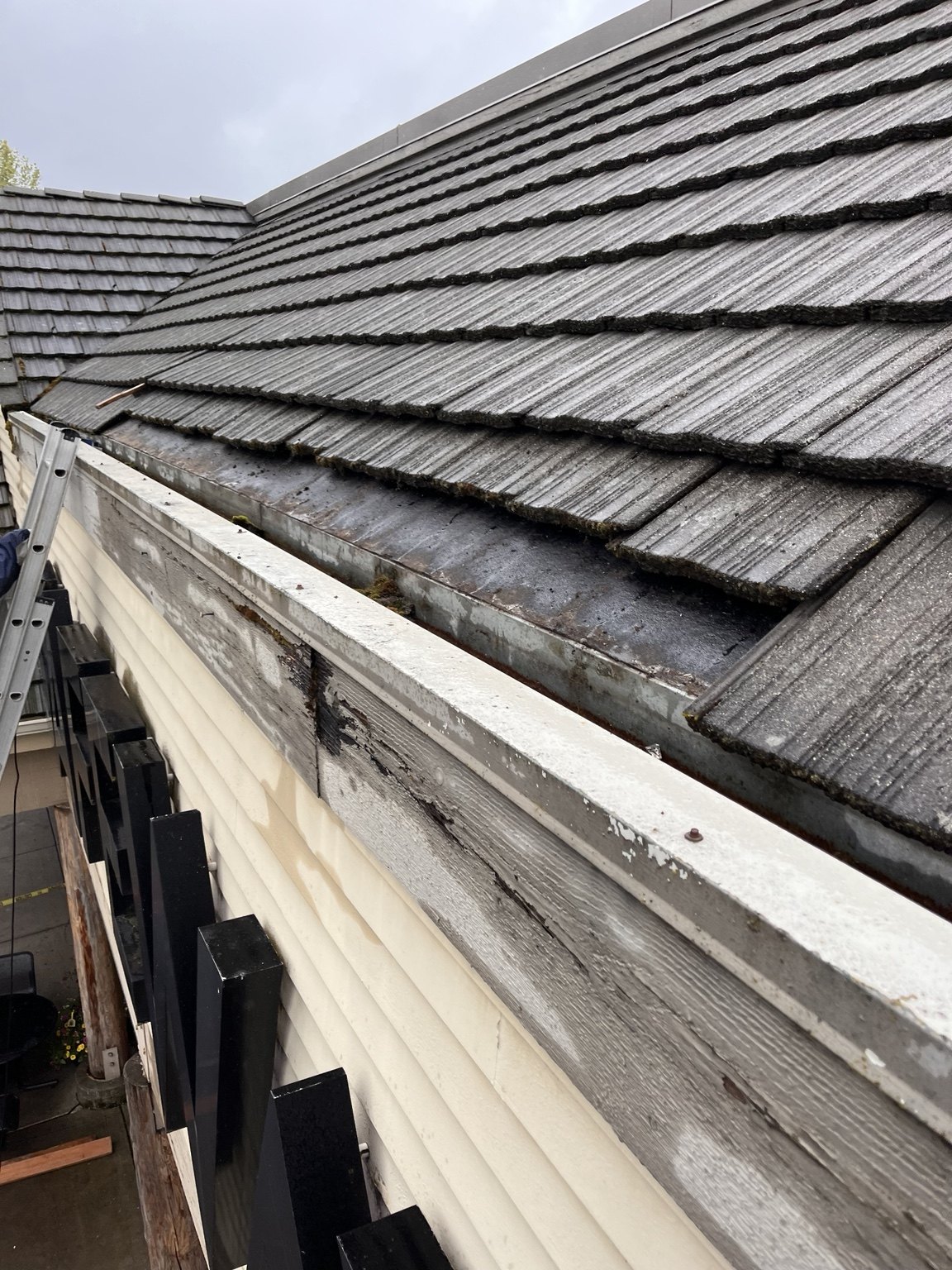 Close view of a roof edge with weathered fascia and exposed gutter brackets